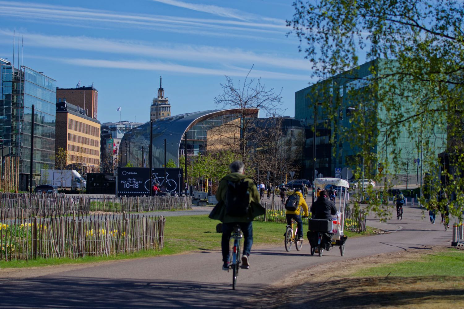 Ciclistas numa ciclovia urbana, entre edifícios modernos