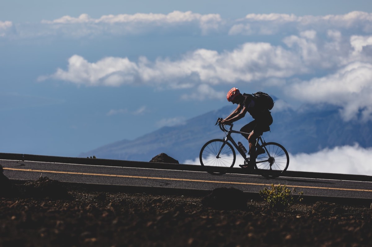 Ciclista numa estrada ao amanhecer